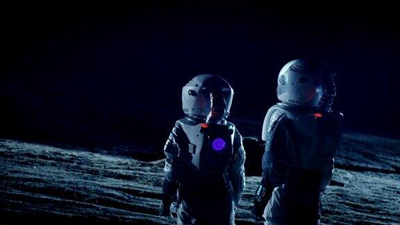 两名宇航员穿着太空服站在外星看黑暗的天空太空旅行宜居世界和殖民概念