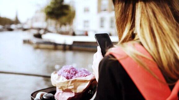 女子骑着自行车在河桥上拍照留长发、送花的女士在网上与朋友分享照片4k