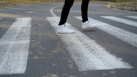 穿运动鞋的男孩走在人行横道上