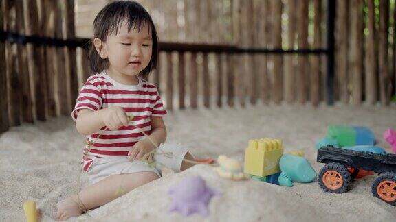 小女孩在沙坑里堆了一堆沙子