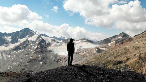 一名男子站在高加索山脉的悬崖上