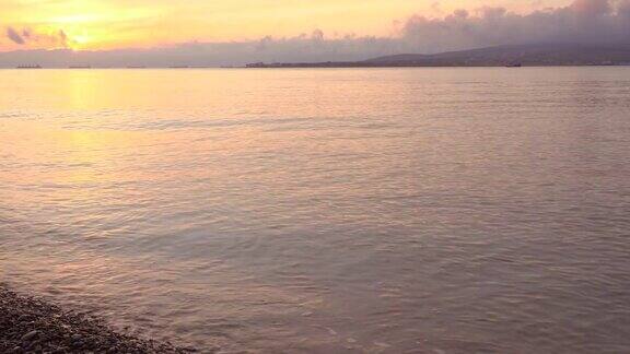 美丽的日落在海滩上船在远处