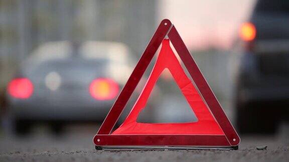在傍晚的城市街道上红色紧急停车标志后面的破碎模糊的闪烁的灯的汽车