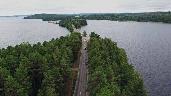 风景鸟瞰图露营车与独木舟的屋顶上的道路通过芬兰湖