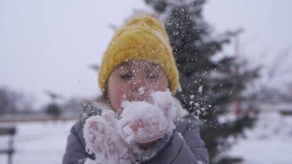 可爱的女孩在寒冷的冬天穿着暖和的衣服玩雪