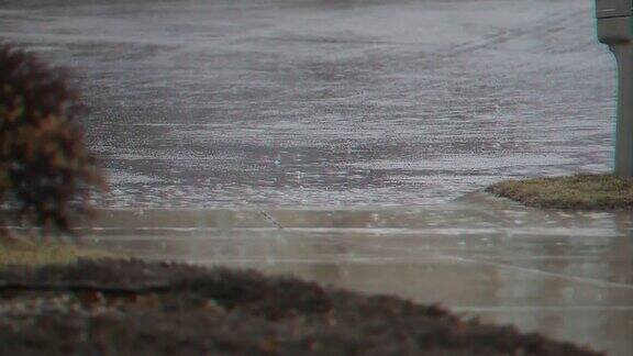 雨水落在住宅车道边的水坑里