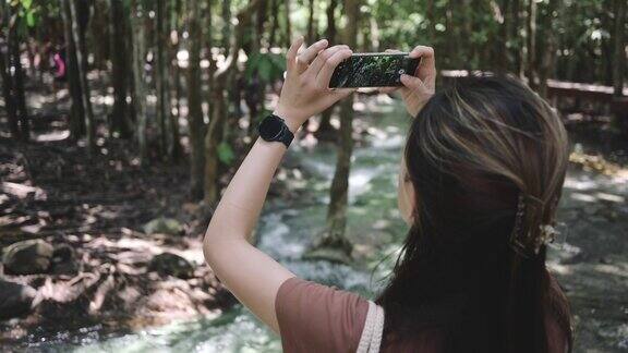 广角拍摄自由独自旅行徒步旅行博客记录了自然绿色森林徒步旅行者手持5g6g互联网智能手机在山上行走的视频
