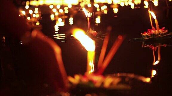 泰国清迈的水牛节手放开浮动的装饰篮子和蜡烛