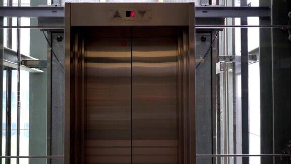 玻璃电梯金属门的特写门上的号码显示电梯在三楼