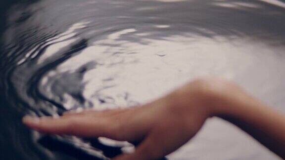 光滑如丝的水面女性用手轻轻泼洒并触摸液体