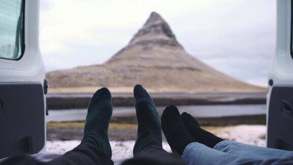 一对夫妇从露营车上看着冰岛的Kirkjufell山