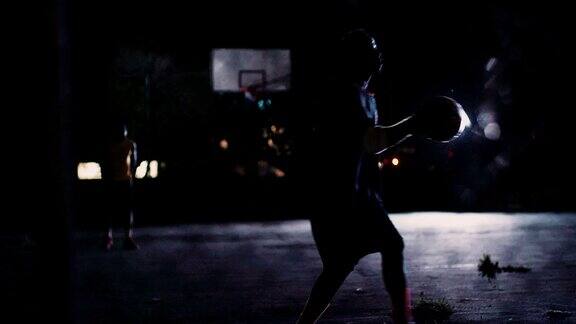篮球运动员晚上独自在球场上练习