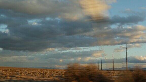 公路旅行开车从死亡谷到拉斯维加斯美国内华达州在美国搭便车旅行高速公路旅行戏剧性的氛围日落山和莫哈韦沙漠荒野从汽车
