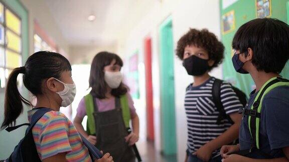 学生在学校走廊里说话戴着防护口罩