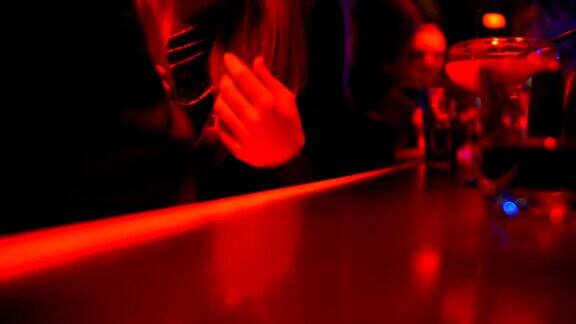 坐在吧台的女人和男人聊天夜店的派对气氛