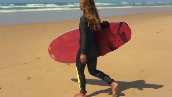 一个快乐的女孩拿着冲浪板走在沙滩上