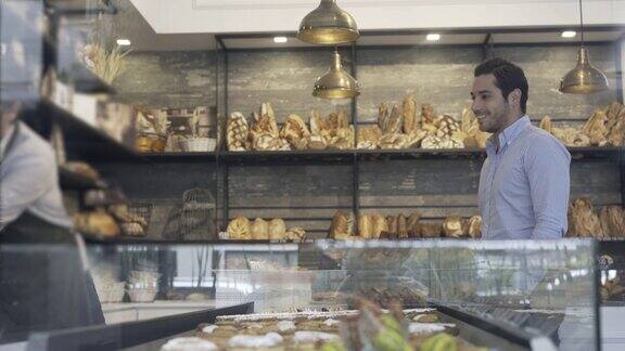 顾客在看面包店的选择和售货员的服务