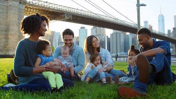 两个家庭带着孩子坐在曼哈顿的桥旁