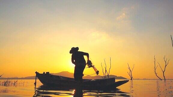 高清慢镜头:日落时分渔夫在渔船上捕鱼