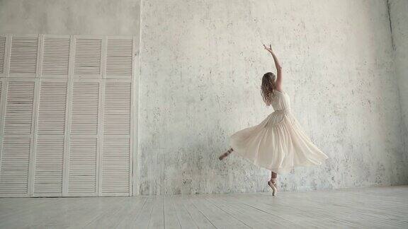 一位优雅的芭蕾舞演员穿着轻盈的裙子穿着尖头鞋踮着脚尖跳舞