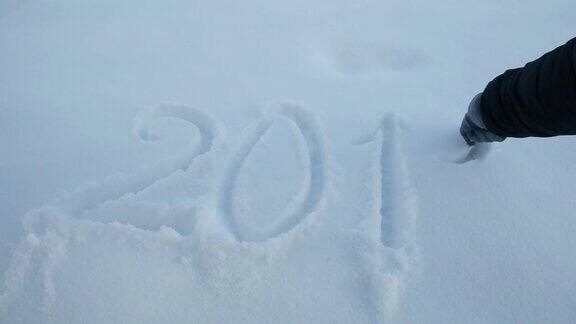 女人的手在白雪上写着2018