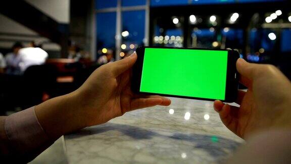 手持绿色显示屏的手机