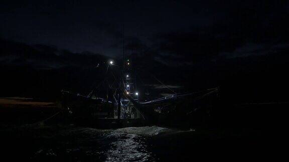 后面的捕虾拖网渔船捕鱼在黎明与网