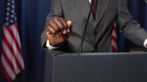 非裔美国政治家发表了一篇感人的演讲做了很多手势只有他的拳头在特写镜头里