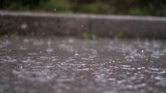 慢镜头特写:秋天的雨滴落入水坑在街道上