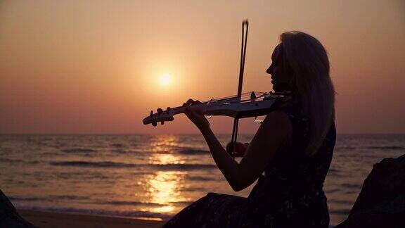 年轻的音乐家在海边拉小提琴