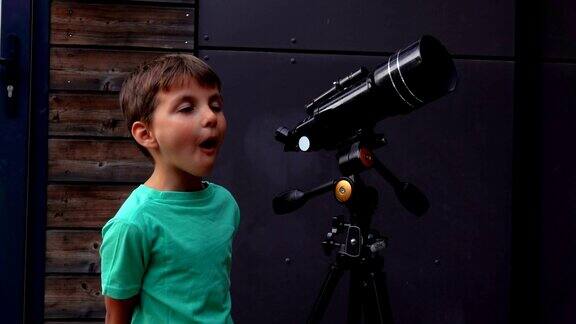 这个快乐的小男孩用望远镜观察天空