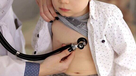 儿科医生用听诊器检查一个小男孩