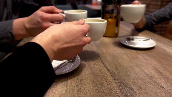 一群朋友在咖啡馆里碰杯喝茶手的特写