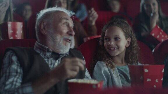 爷爷在电影院向他的孙女解释电影
