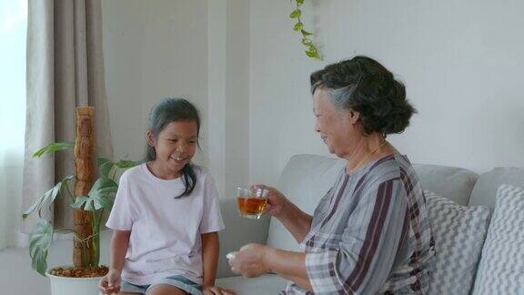孙女正在客厅里给她奶奶倒一杯茶