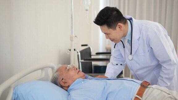 亚洲医生带着听诊器照顾躺在病床上的老年病人