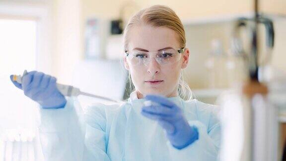 一名女科学家在实验室里用移液管分析液体