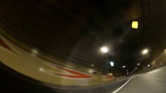 拍摄于城市公路隧道黄昏时分在城市高速公路上行驶穿过城市的车流