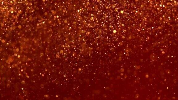 在红色液体中平稳下落的金色尘埃颗粒