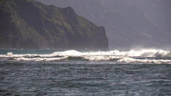 在考艾岛上海浪朝着山脉冲去