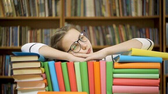 女孩读完一本书后摘下眼镜一个女孩躺在图书馆的书上