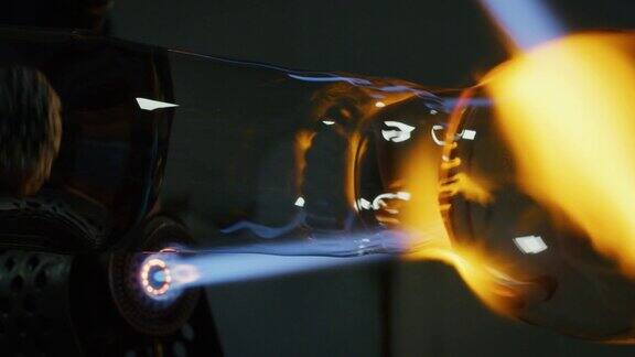慢镜头的玻璃鼓风机工作与火焰在一个手工艺术品玻璃从珍贵的水晶在车间