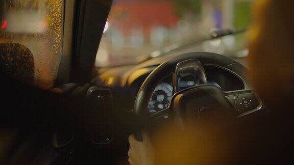 夜间灯光下城市街道上的女司机驾驶汽车