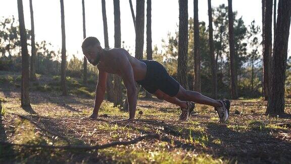 日落时分年轻人在森林里做俯卧撑和健身