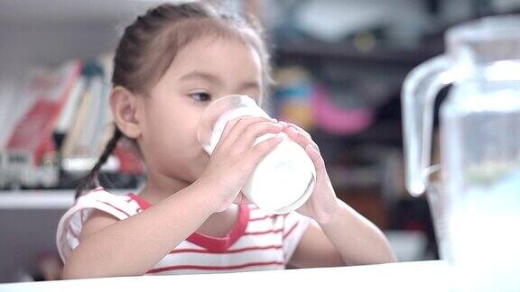 小女孩在餐厅里喝牛奶
