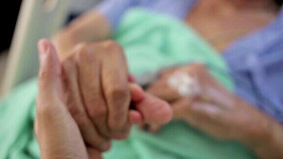 医院的老病人牵着家人的手