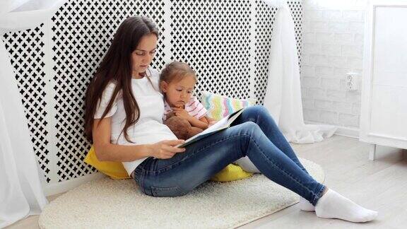 年轻的母亲在为她的小女儿读书