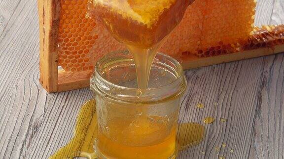蜂蜜正以蜂巢为背景流入玻璃罐中