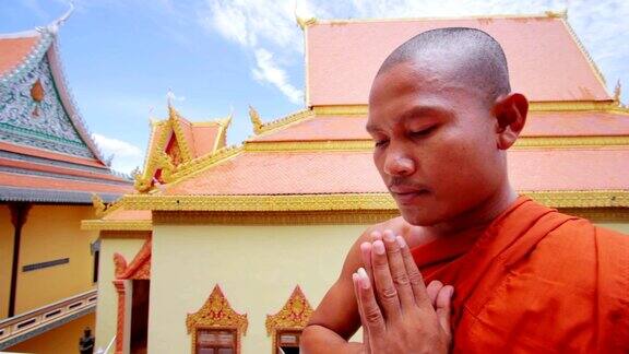 身穿橙色僧袍的和尚在寺庙里祈祷