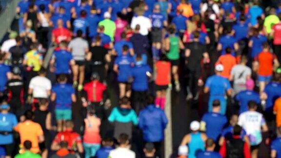 城市马拉松赛事鸟瞰一群跑步运动员人们的t恤街道上挤满了参加大众赛跑的选手